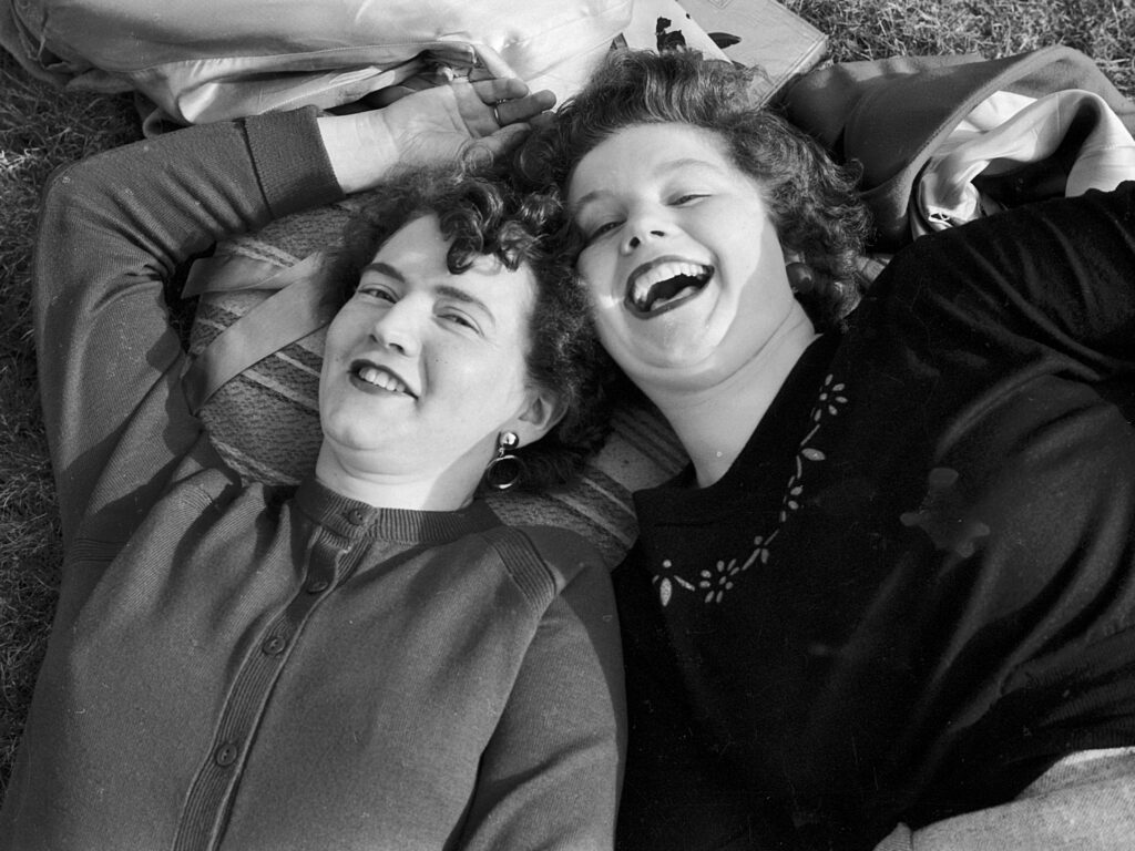 Photograph Tony Fitzmaurice took in 1953 in Ballybunion, Co Kerry, Ireland , shows two stylish young women lying on the grass on a summer afternoon. They are laughing.